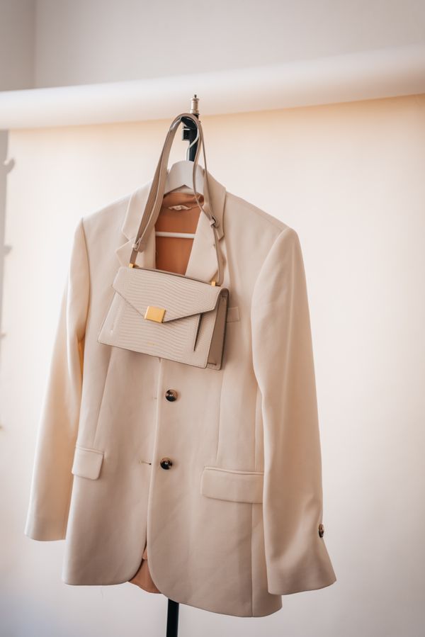 Cream blazer and small bag hung on a rail — PNW Production on Pexels