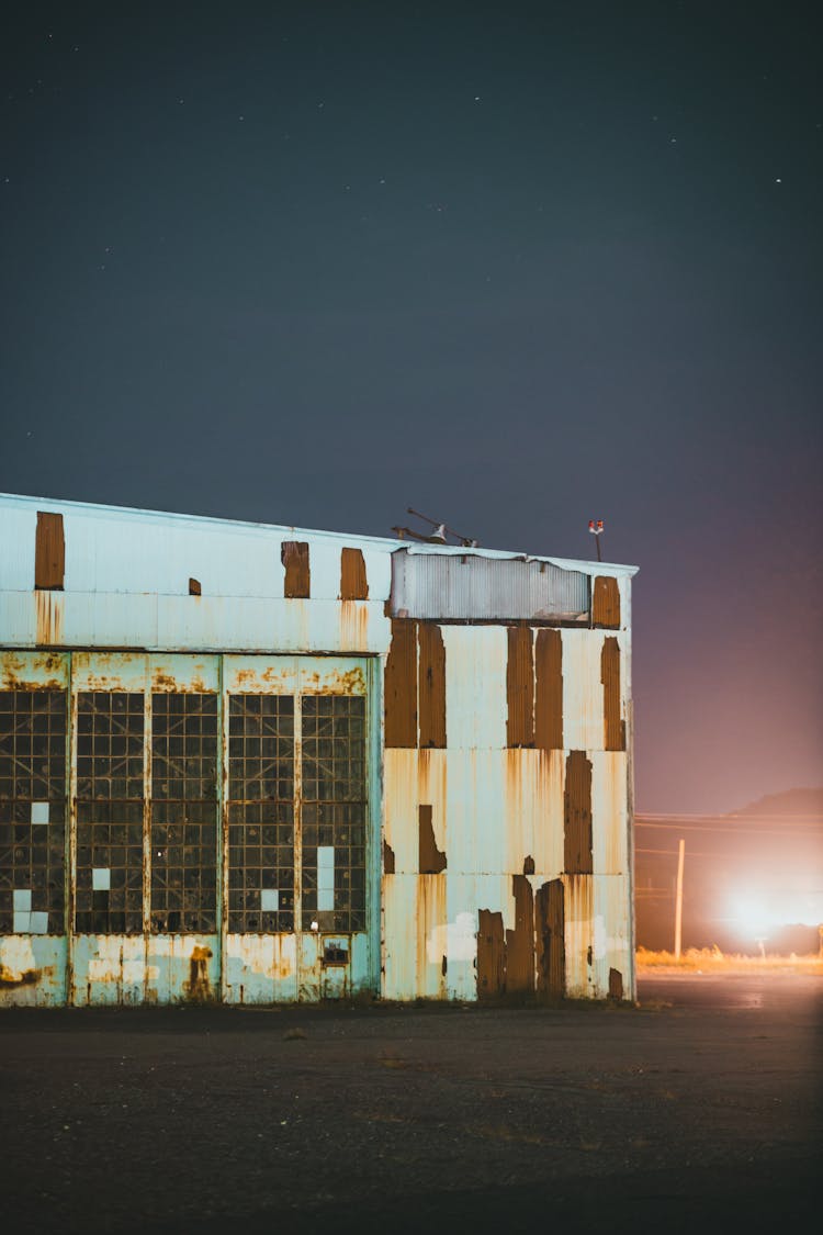 Light Near Abandoned Old Warehouse At Night