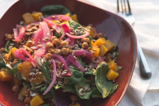 Delicious close-up of a fresh salad with chickpeas, spinach, and pickled onions.