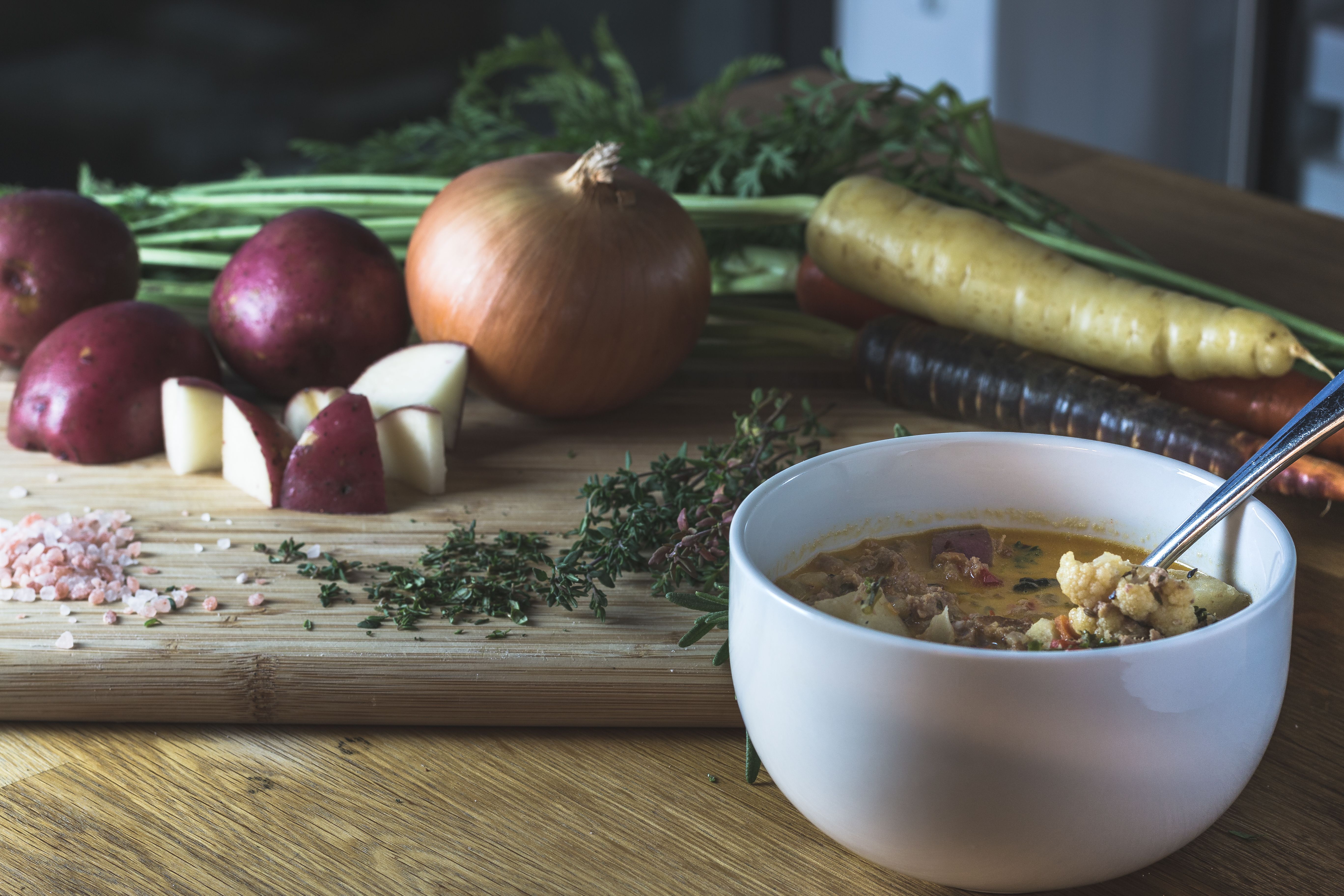 Close-up of chunky potato and carrot soup garnished with herbs