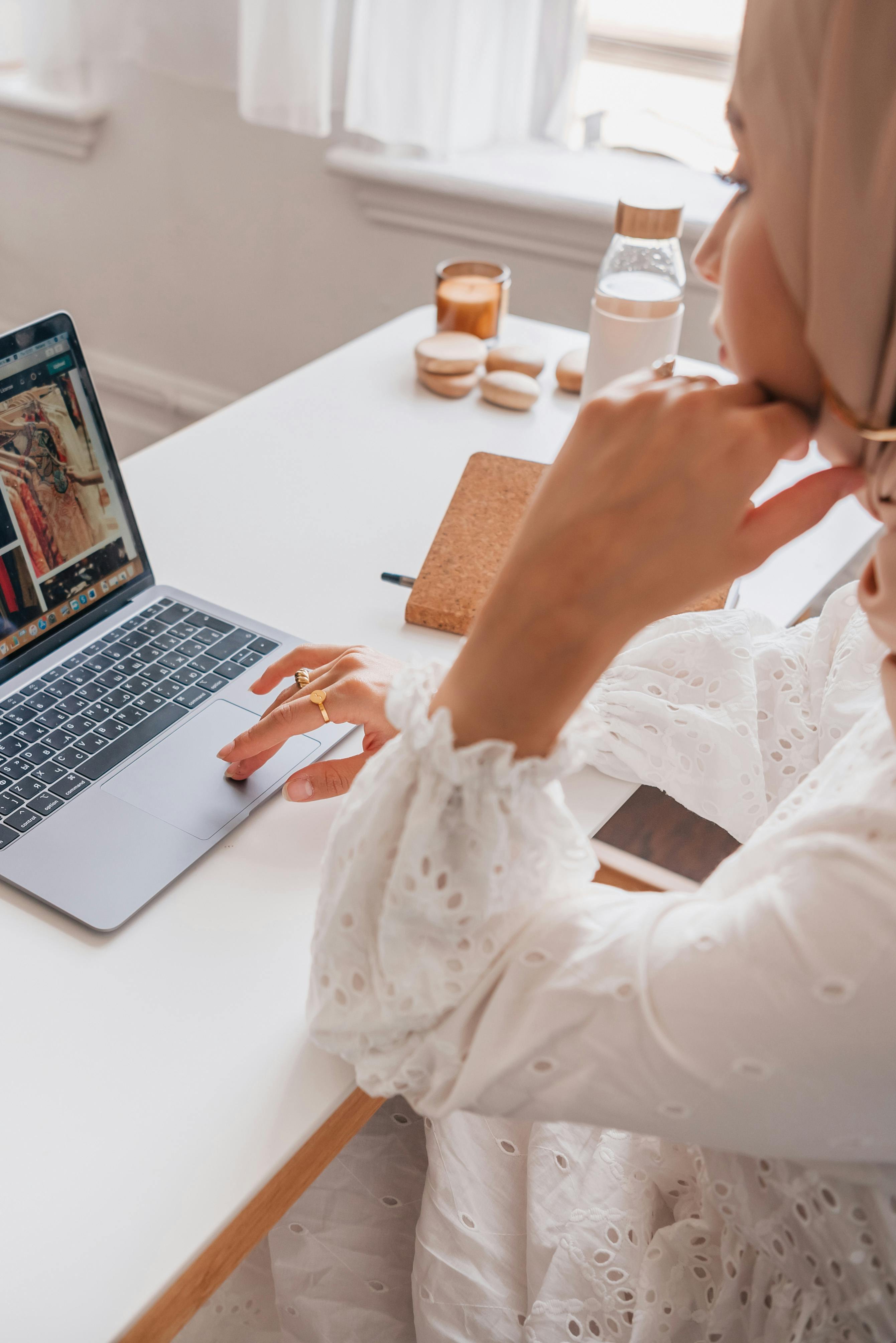 Gratis Wanita Berkemeja Putih Lengan Panjang Menggunakan Macbook Pro Foto Stok