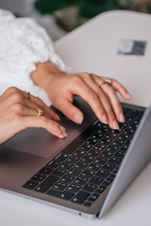 Free Hands of a woman typing on a laptop keyboard indoors, showcasing rings and fashion. Stock Photo
