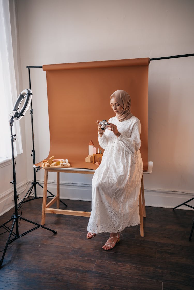 Woman In White Dress Holding A Camera