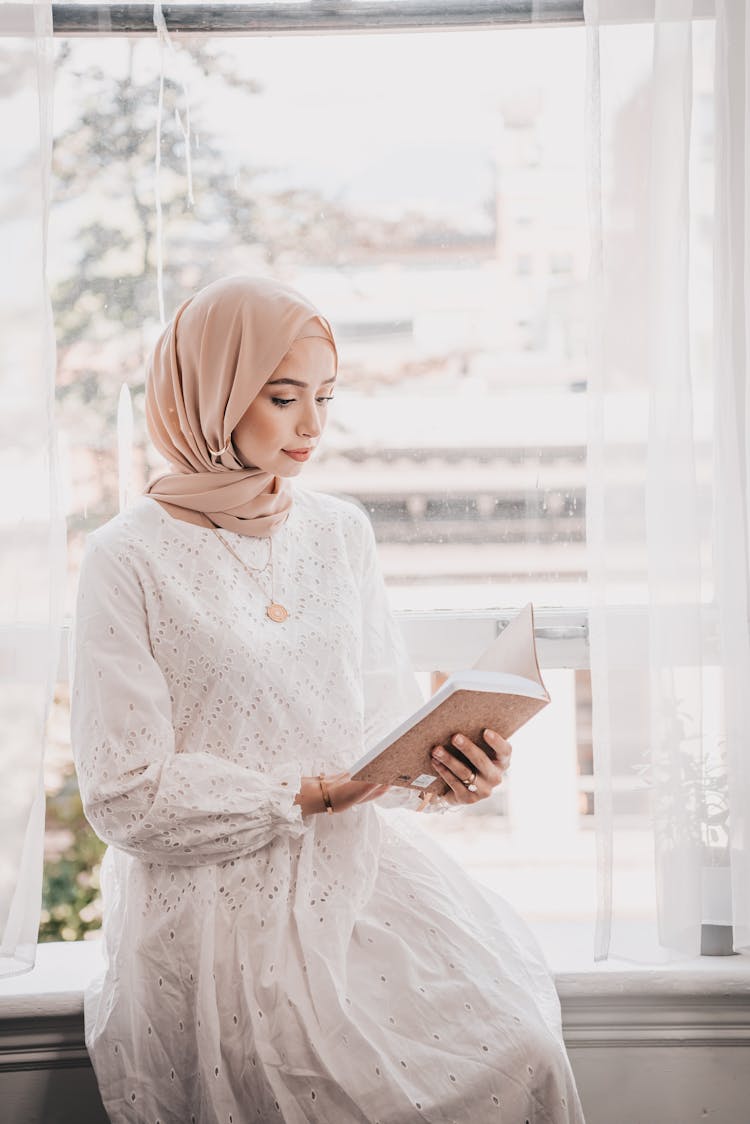 A Woman In White Dress Reading A Book