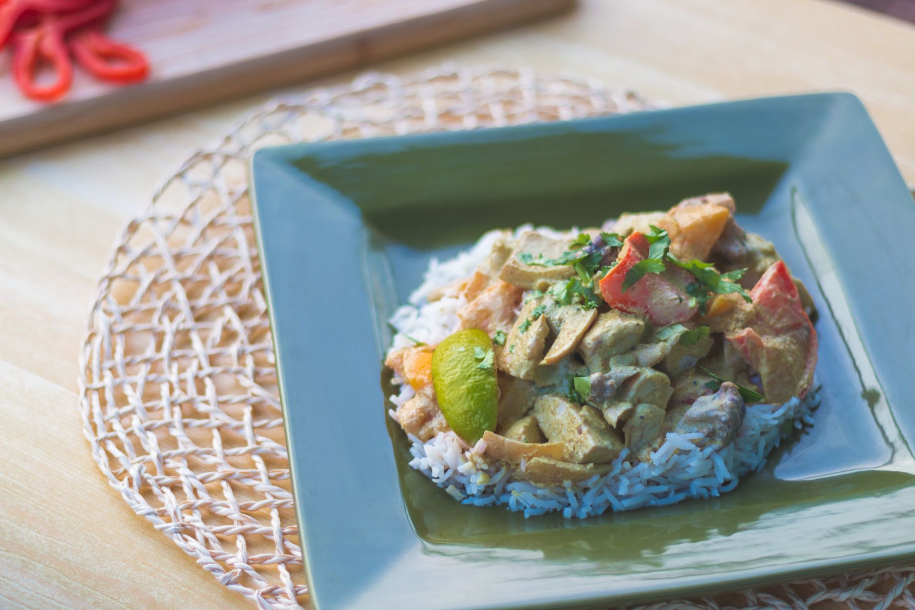 Bowl of golden Trinidadian curry chicken garnished with fresh cilantro, showing the rich sauce and vibrant colors of Caribbean spicing