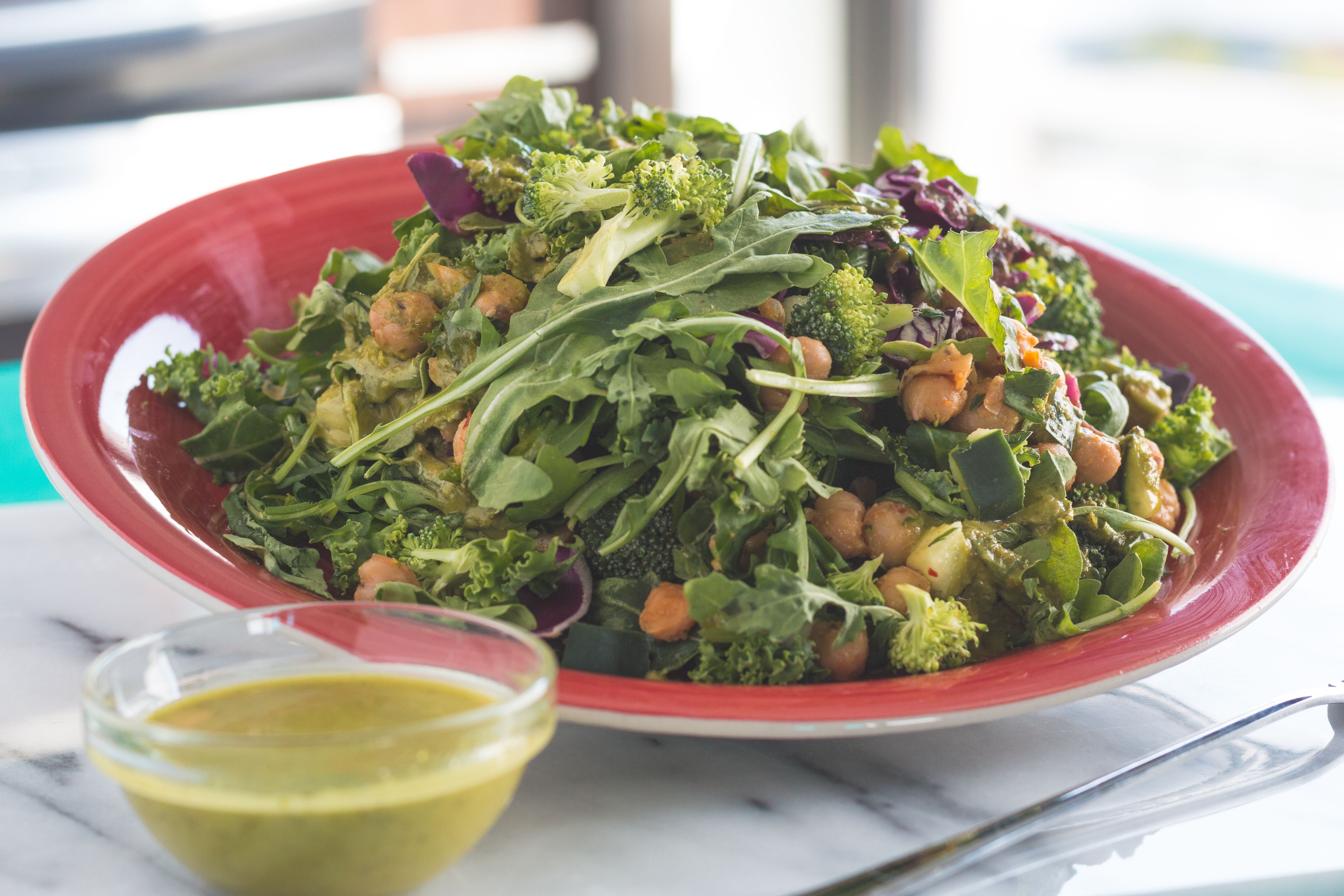 Free Healthy vegetable salad with chickpeas and green dressing on a table. Stock Photo