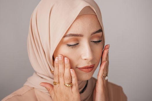 Portrait of a serene woman in hijab with soft natural makeup, showcasing elegance and tranquility.