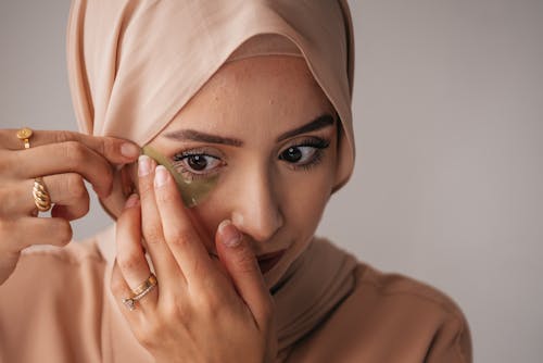 Free A Woman Putting an Under Eye Patch Stock Photo