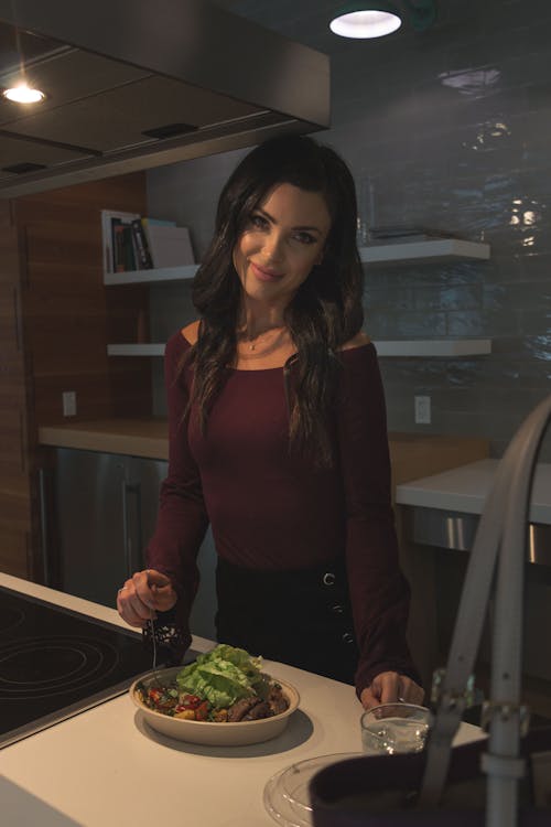 Woman Smiling by Table with Salad