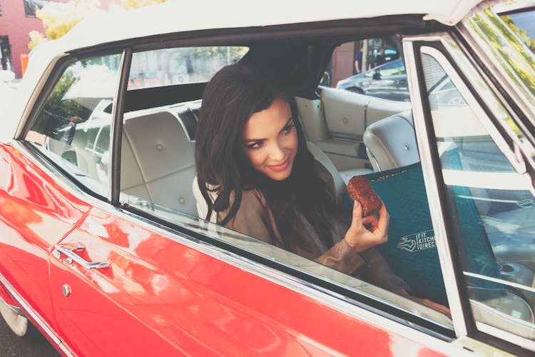 A Woman Holding A Bread Inside A Car