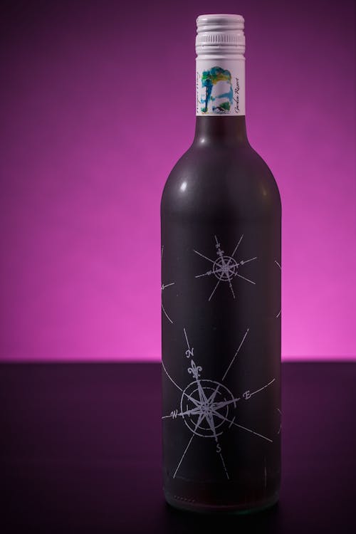 A Bottle of Alcoholic Drink over Purple Surface