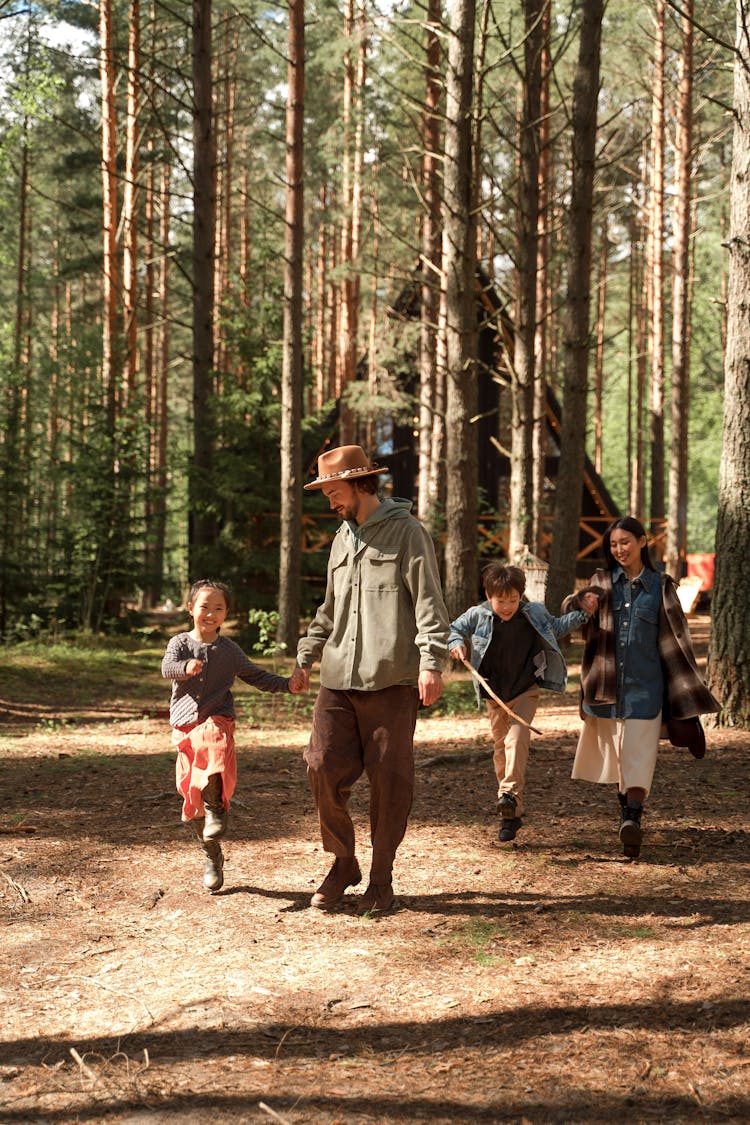 Parents With Kids Walking In The Forest