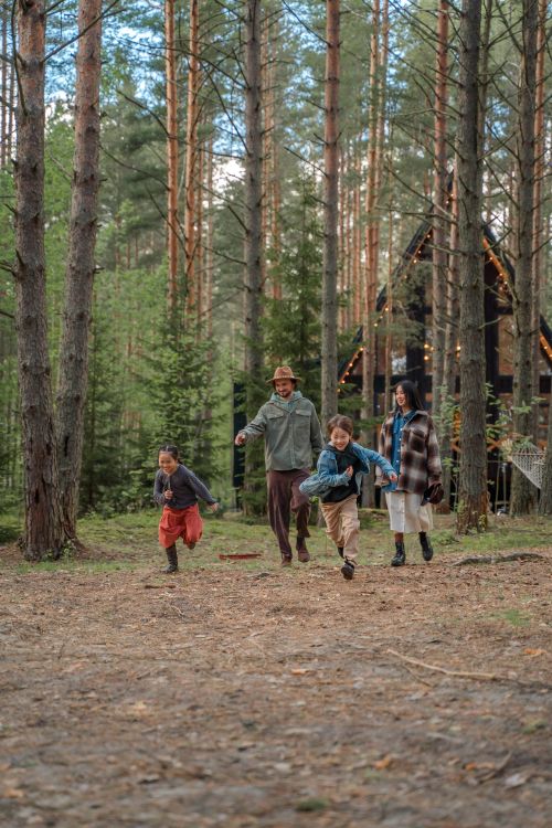 Free Happy family playing and running through the forest, enjoying a vacation together. Stock Photo