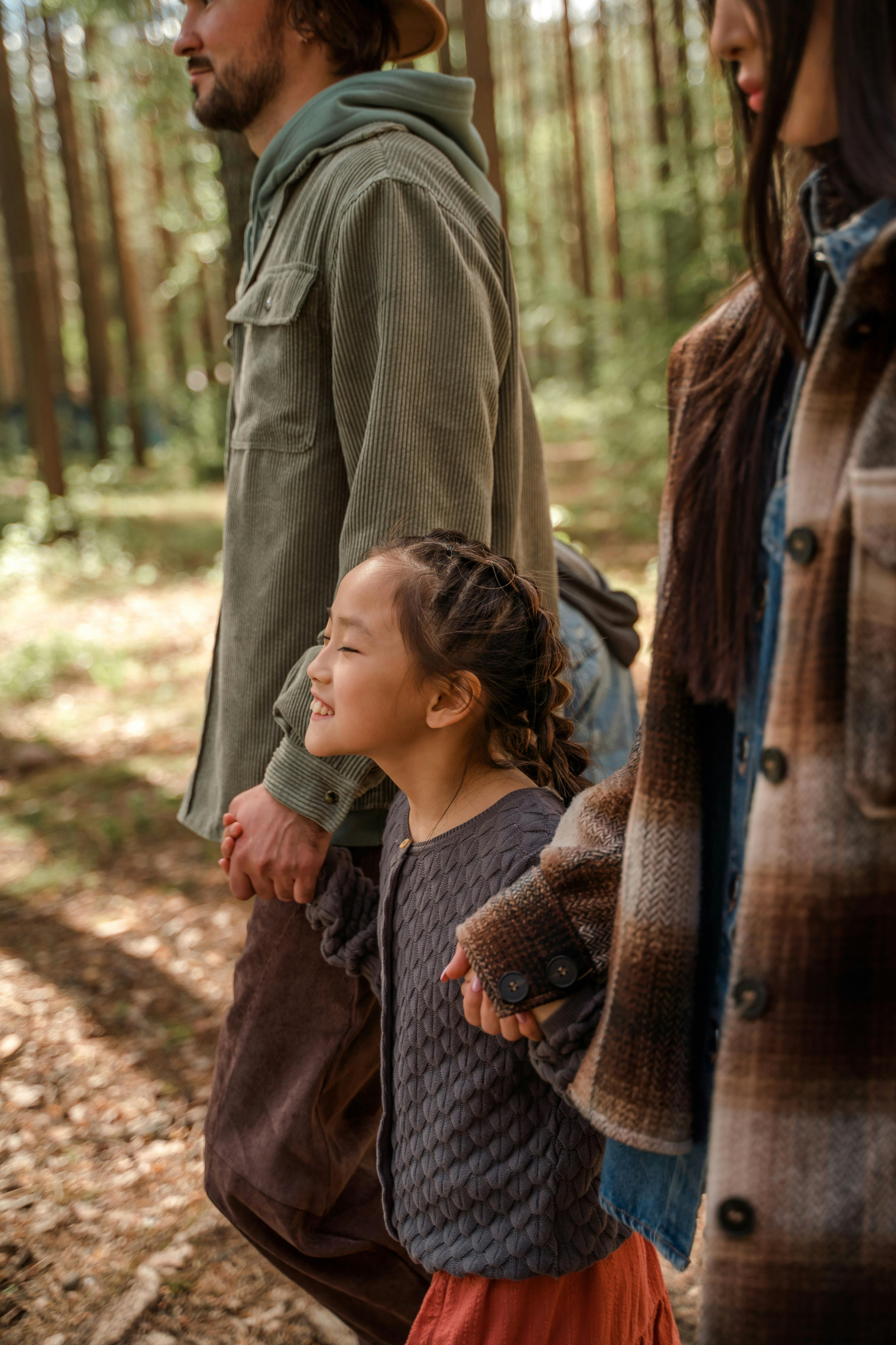 a man and a woman holding hands with their daughter