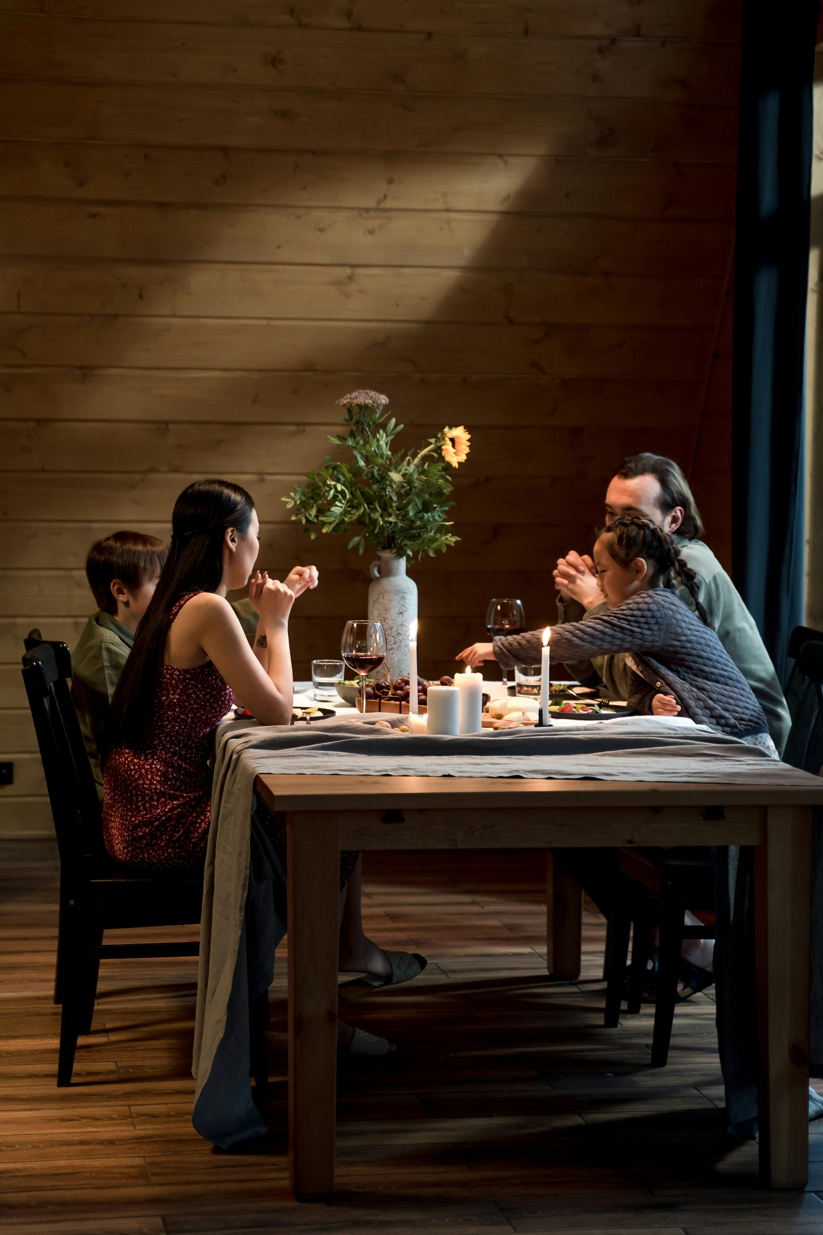 A family gathered at a rustic table enjoying a cozy dinner together.