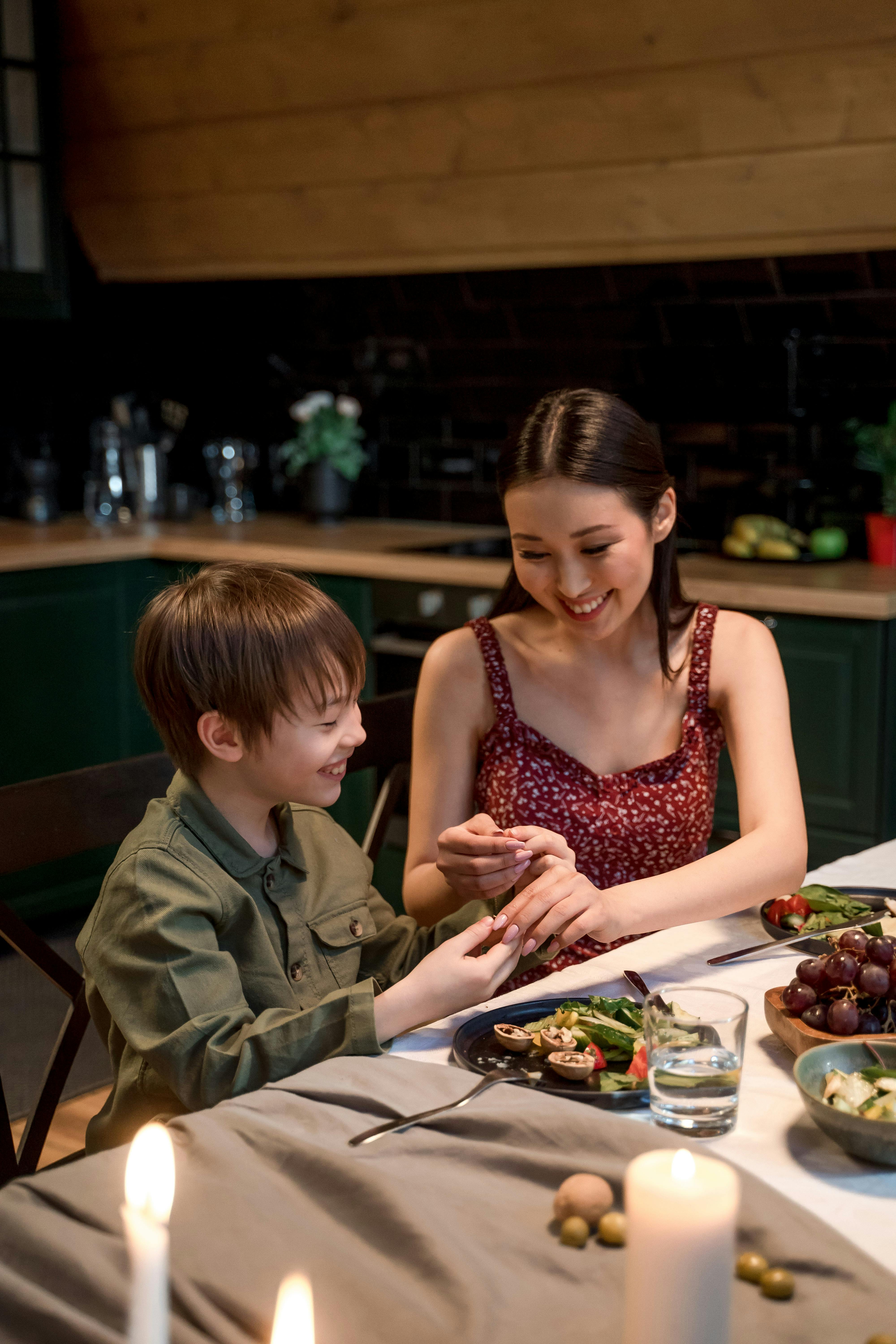 a woman and boy sitting at the tablet together