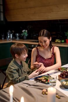 A joyful moment between mother and son sharing a dinner at home.