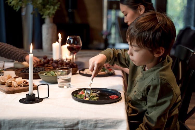 A Boy Eating In The Table