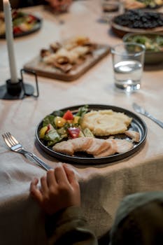 A warm family dining scene featuring a plate of fresh salad, mashed potatoes, and chicken, ideal for food photography.