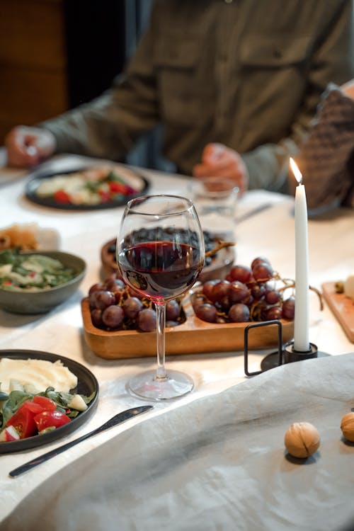 Glass of Wine Beside a Lighted Candle