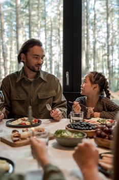 Father and daughter share a heartfelt dinner moment at home, bonding over a meal.