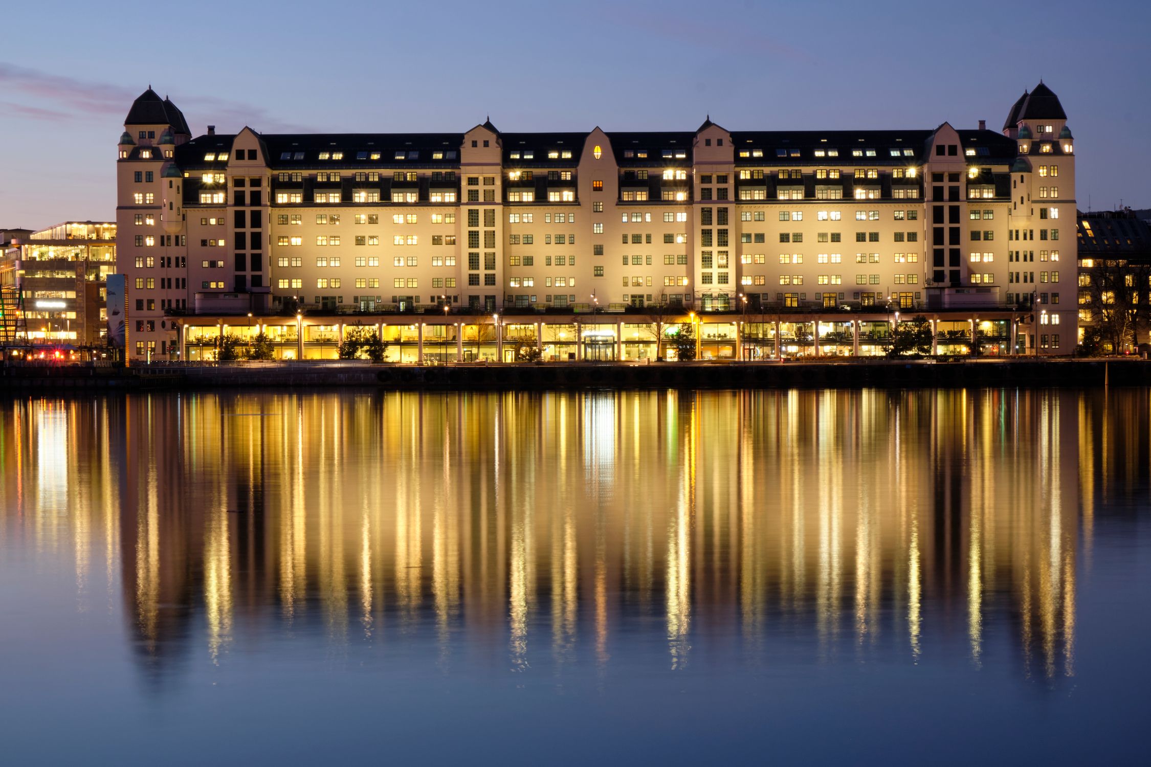 Havnelageret building reflecting on water during twilight in Oslo, Norway.