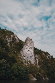 Majestic rock sculpture of Decebalus in Orșova, Romania, surrounded by nature.