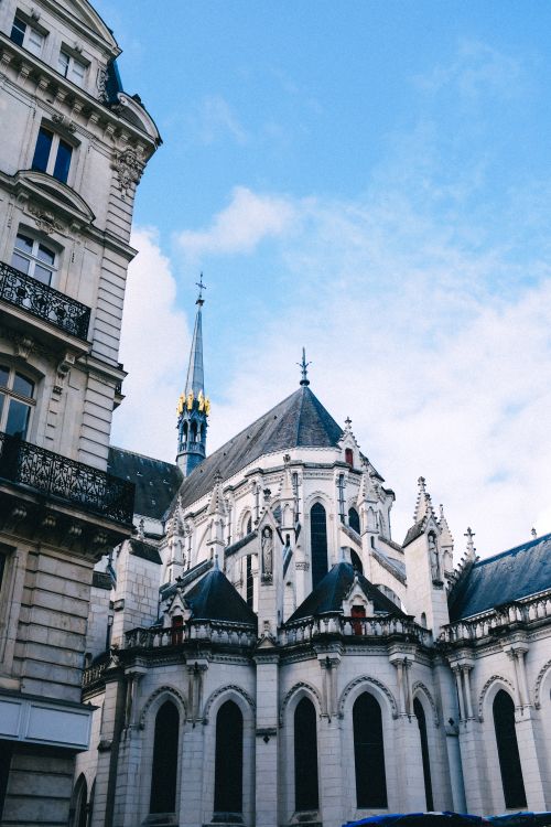 Free A stunning gothic church facade with intricate architecture under a clear blue sky. Stock Photo