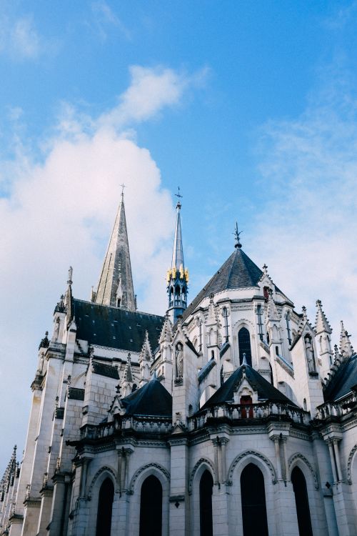 Free A stunning view of a gothic cathedral with intricate architecture under a clear blue sky. Stock Photo