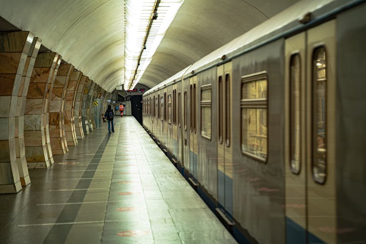 People Walking On A Subway Platform Near A Train