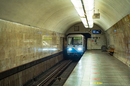 A subway train approaches a Moscow metro station platform, capturing urban transit dynamics.