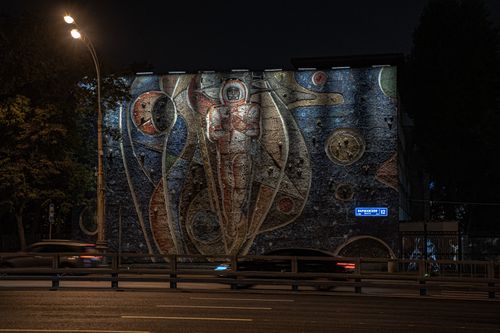 Free A striking astronaut mural on a city building in Moscow, glowing under streetlights at night. Stock Photo