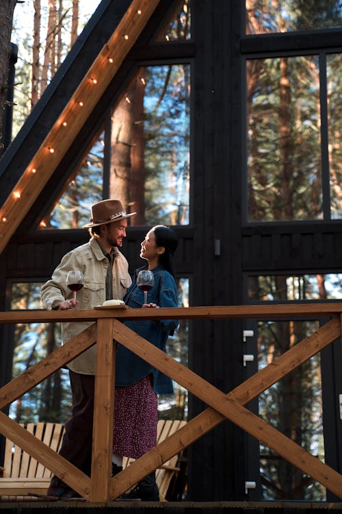 A Couple Looking at Each Other Outside the Wooden Cabin