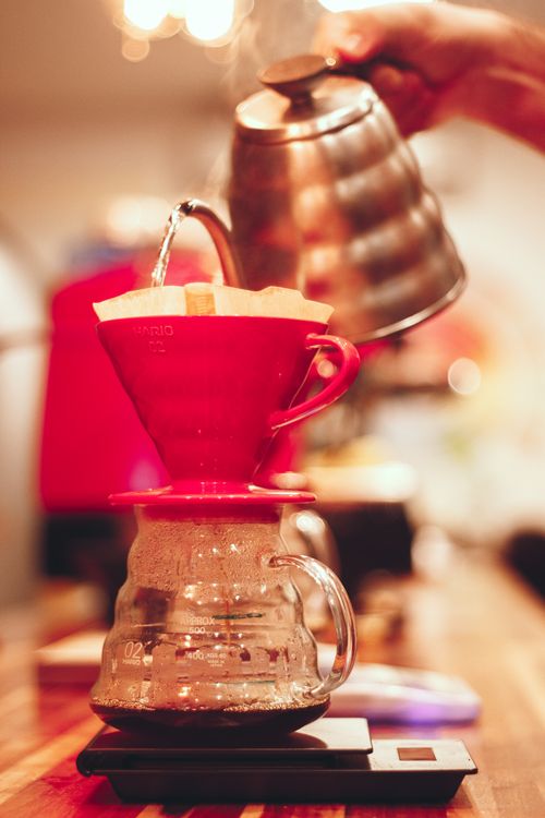 Free Close-up of hot coffee being brewed using a pour-over method in a cozy kitchen setting. Stock Photo