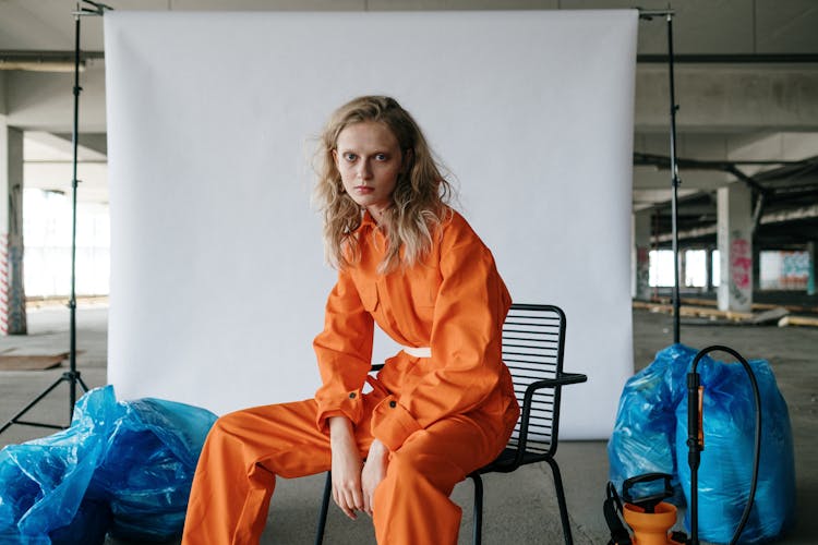 A Woman Sitting Wearing Orange Suit 