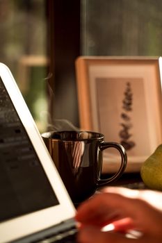 A serene workspace scene featuring a steaming coffee cup and a laptop, ideal for productivity.