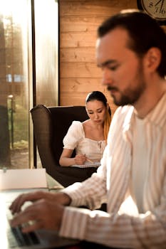 A couple working remotely in a bright, cozy room with a modern aesthetic.