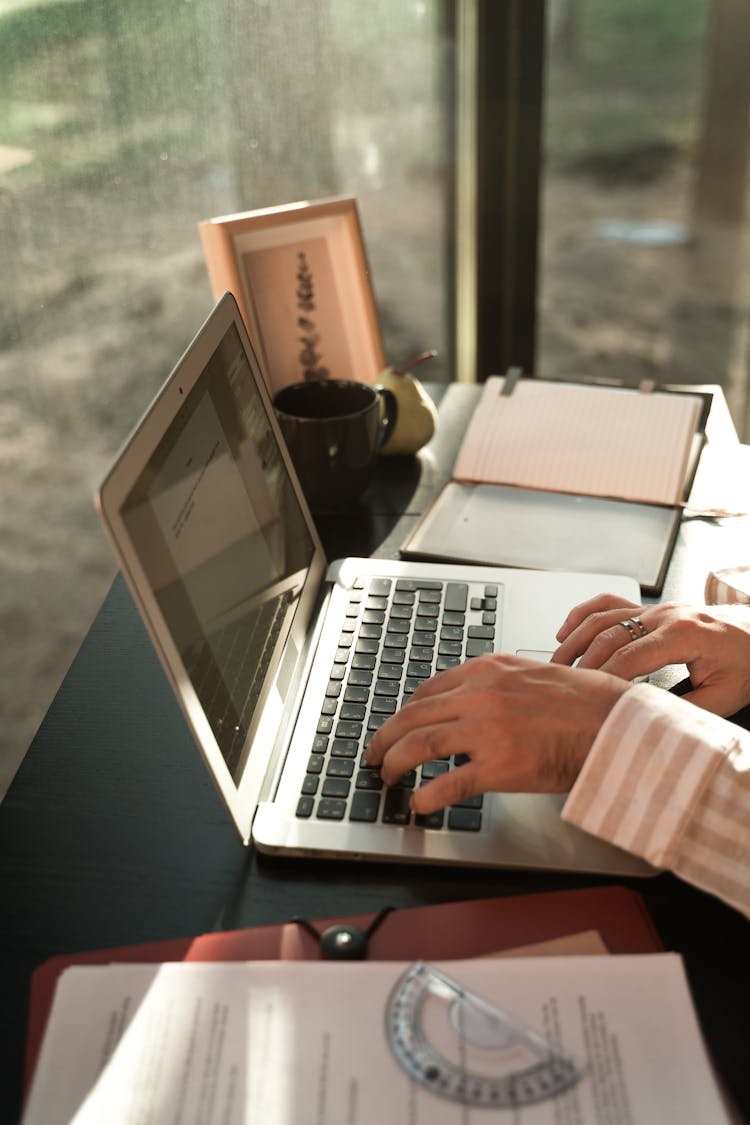 Person Typing On His Laptop