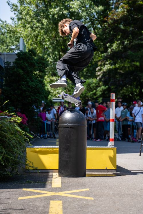 Free Skilled rider performing a high scooter trick in a lively urban environment. Stock Photo