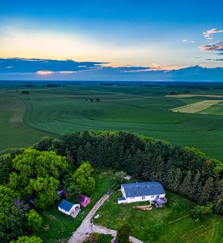 Stunning aerial view of a countryside estate surrounded by lush farmland in Minnesota at sunset.