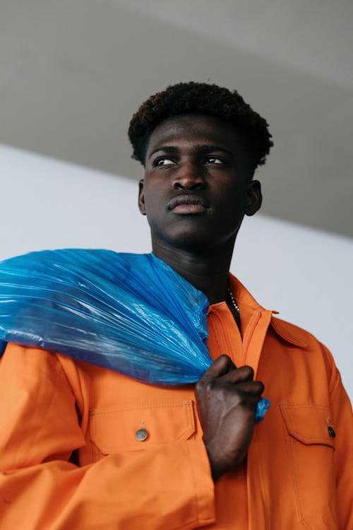 A Low Angle Shot of a Man Carrying a Blue Plastic Bag