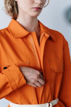 A stylish orange jacket with detailed pockets and a zip, perfect for modern fashion.