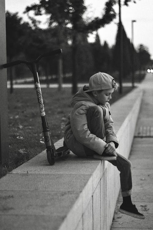 Black and White Photo of Sad Boy Wearing Cap
