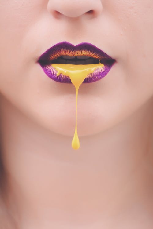 婦女的紫色和黃色嘴唇與黃色液體