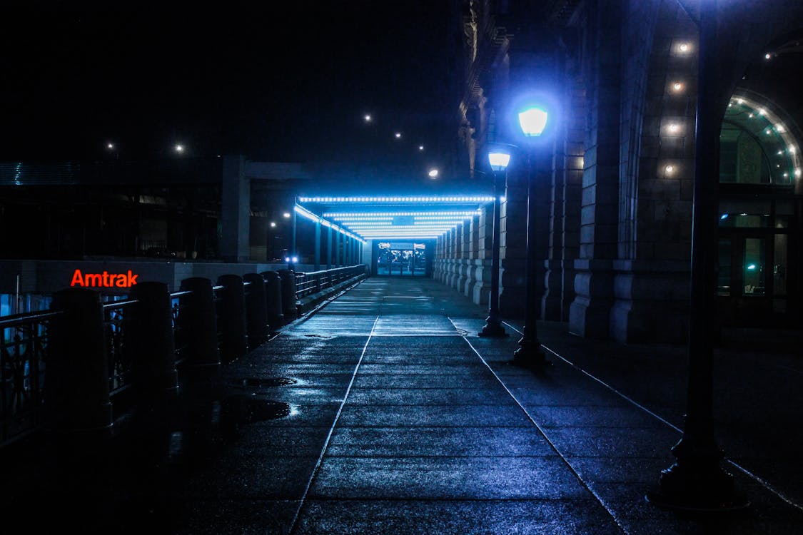 бесплатная Черная уличная лампа на пьедестале возле рельса каботажного поезда Стоковое фото