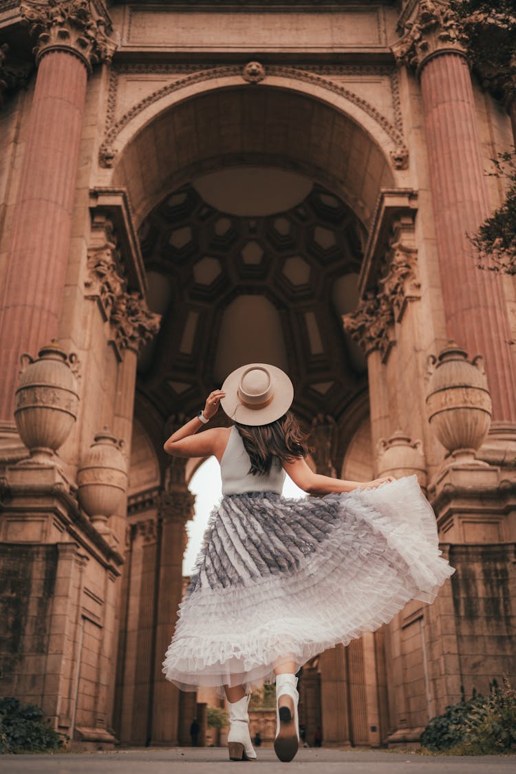 Woman In Dress Posing Near Old Stone Building