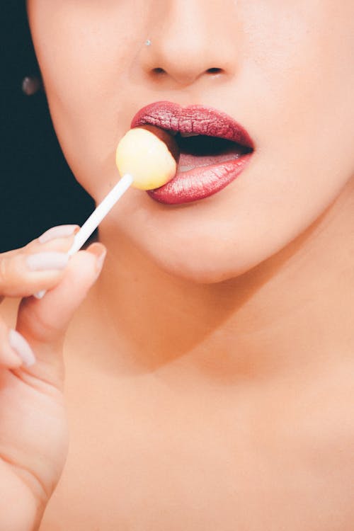 Woman With Red Lipstick Licking a Lollipop
