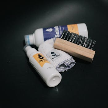 A collection of cleaning tools, including sprays and brushes against a black backdrop.