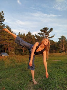 A young woman with blonde hair stretches gracefully in a sunlit forest meadow.