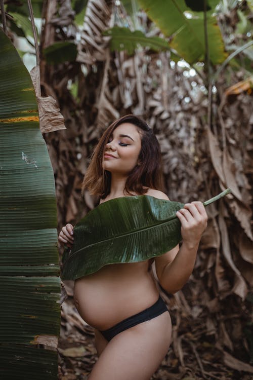 Free Pregnant Woman Covering Herself with a Leaf  Stock Photo